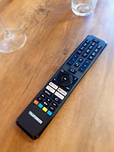 a remote control sitting on top of a wooden table at Long Stay Appartement Kiel in Kiel
