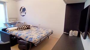 1 dormitorio con 1 cama y TV. en Alimagia, en Lecco