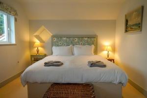 a bedroom with a large bed with two towels on it at San Rocco in Bembridge