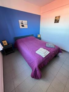 a purple bed in a room with a blue wall at Departamento Libra XX Frente al mar! Promos primavera! in Villa Gesell