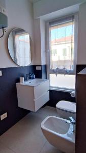 bagno con lavandino, servizi igienici e specchio di Alimagia a Lecco