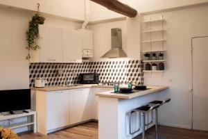 Una cocina con gabinetes blancos y encimera. en Cozy apartment in Pratello, en Bolonia