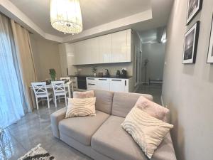 a living room with a couch and a kitchen at Apartament nad Łyną by RENT4YOU in Olsztyn