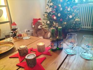 un osito de peluche sentado en una mesa con un árbol de Navidad en Coeur d'Elsass "RAPP"appartement avec parking en Colmar