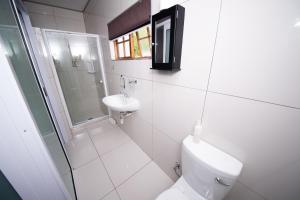 a white bathroom with a toilet and a sink at Kleinplasie Guesthouse in Springbok