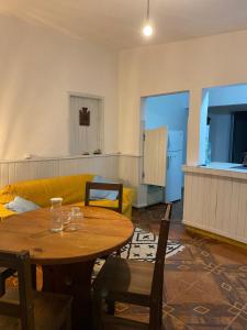 a living room with a table and a yellow couch at Casa de 1 Dormitorio ubicado en planta baja. A 150 mts de la playa en La Aguada y Costa Azul, La Paloma, Rocha in Costa Azul