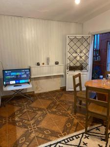 a living room with a table and a tv and a table and chair at Casa de 1 Dormitorio ubicado en planta baja. A 150 mts de la playa en La Aguada y Costa Azul, La Paloma, Rocha in Costa Azul
