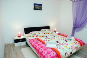 a bedroom with a bed and two pink candles on it at Holiday home Nona in Motovun