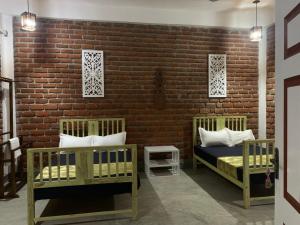 a bedroom with two beds and a brick wall at Sky 14 Resort Yala in Madam