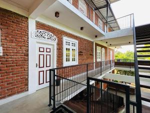 a brick building with a white door and stairs at Sky 14 Resort Yala in Madam