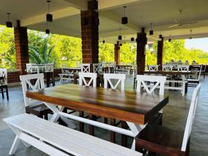 Sky 14 Resort Yala في Madam: وجود طاولة وكراسي خشبية كبيرة في المطعم