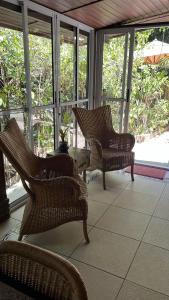 um alpendre com 2 cadeiras e uma mesa em Chalé de Madeira nr01 - Exuberante Flora e Fauna - IMBASSAI em Imbassaí