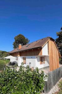 a white house with a wooden roof and a fence at House-tanjevica in Kostanjevica na Krki