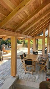 un patio de madera con mesa y sillas de madera en House-tanjevica, en Kostanjevica na Krki