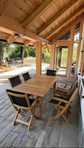 a wooden table and chairs on a wooden deck at House-tanjevica in Kostanjevica na Krki