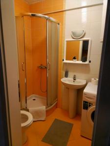 uma casa de banho com um chuveiro, um WC e um lavatório. em Anchy Apartment em Belgrado