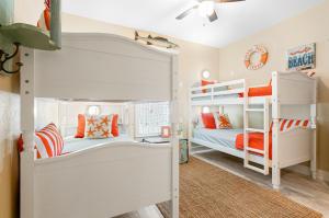two bunk beds in a room with orange accents at Hot Tub Golf Cart Near beach Coastal Retreat in Bolivar Peninsula +38 photos