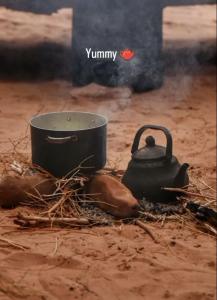 a pot and a tea kettle on the ground at um sabatah Camp in Wadi Rum