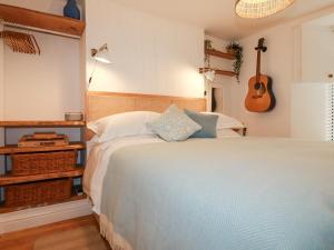 a bedroom with a bed and a guitar on the wall at Waves End in St Austell