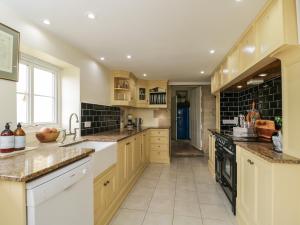 uma grande cozinha com armários brancos e um fogão em The Gate House em Cirencester