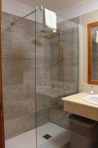 a glass shower in a bathroom with a sink at Casa do Sol in Ponta do Sol