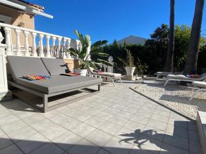 eine Terrasse mit einer Bank auf einer Terrasse in der Unterkunft Villa Benjamina avec piscine climatisée in Altea