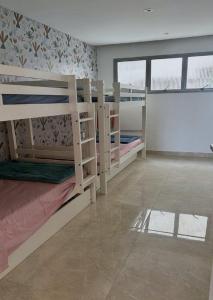 グアルジャにあるCondomínio Costa Esmeraldaのタイルフロアの客室で、二段ベッド2組が備わります。