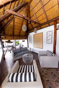 a large living room with couches and a large ceiling at Kleinplasie Guesthouse in Springbok