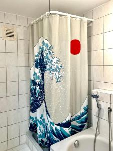 a shower curtain of a wave in the ocean at Lotus Apartment in Fichtenberg