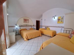 a room with three beds with orange sheets at Il Rifugio Di Ela in Furore