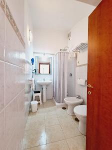 a white bathroom with two toilets and a sink at Il Rifugio Di Ela in Furore