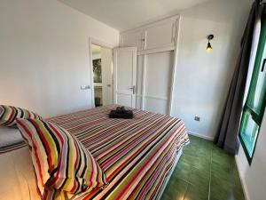 a bedroom with a bed with a striped blanket at Casa Luna in Puerto del Carmen +34 photos