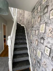a staircase with a wall with pictures on it at Connswater Town House Belfast in Belfast