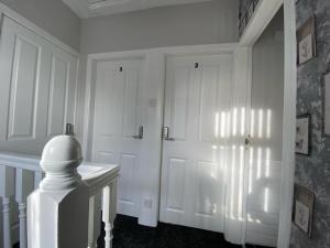 a white room with a door and a table at Connswater Town House Belfast in Belfast