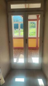 una puerta abierta con 2 ventanas en una habitación en Appartamento Dolomiti 138 Villaggio Turistico, en Carbonin