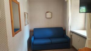 Appartamento Dolomiti 138 Villaggio Turistico في كاربونين: كرسي أزرق في غرفة مع مرآة