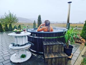 a woman in a hot tub in a garden at Pensiunea Conacul lui Horia in Bistriţa