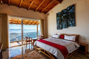 a bedroom with a large bed and a balcony at Shree Parijat Resort At Mukteshwar Hill Station with Himalayan View in Mukteshwar