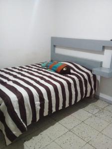 uma cama com um cobertor listrado preto e branco em Posada en celaya em Celaya
