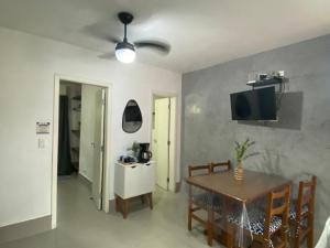 a dining room with a table and a tv on the wall at Flat juquehy L&H in Juquei