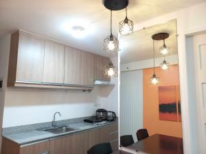 a kitchen with a sink and a counter with lights at My Arezzo 1 BR Condo in Davao City