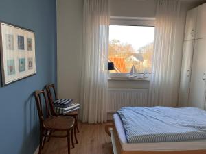 Schlafzimmer mit einem Bett und einem Fenster in der Unterkunft Ferienwohnung Antje auf Borkum in Borkum