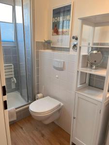 ein kleines Bad mit einem WC und einer Dusche in der Unterkunft Ferienwohnung Antje auf Borkum in Borkum