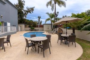 patio ze stołami i krzesłami przy basenie w obiekcie Hampton Inn by Hilton Guadalajara-Aeropuerto w mieście Guadalajara