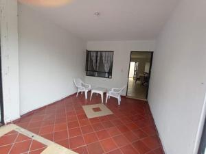 um quarto com 2 cadeiras e uma mesa num piso de azulejo em Quintas de las Acacias Villavicencio em Villavicencio