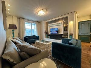 a living room with two couches and a tv at Amplo apartamento 03 dorm Centro de Gramado in Gramado