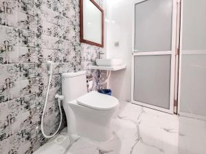 een witte badkamer met een douche en een toilet bij Raalhu Fonu Maldives in Mahibadhoo