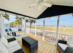 een veranda met witte stoelen en een plafondventilator bij Vacation Cottage North Myrtle Beach 69 in Myrtle Beach