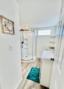 baño con ducha y alfombra verde en Vacation Cottage North Myrtle Beach 69 en Myrtle Beach