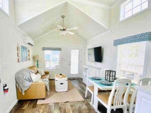 uma sala de estar com uma ventoinha de tecto e uma mesa em Vacation Cottage North Myrtle Beach 68 em Myrtle Beach